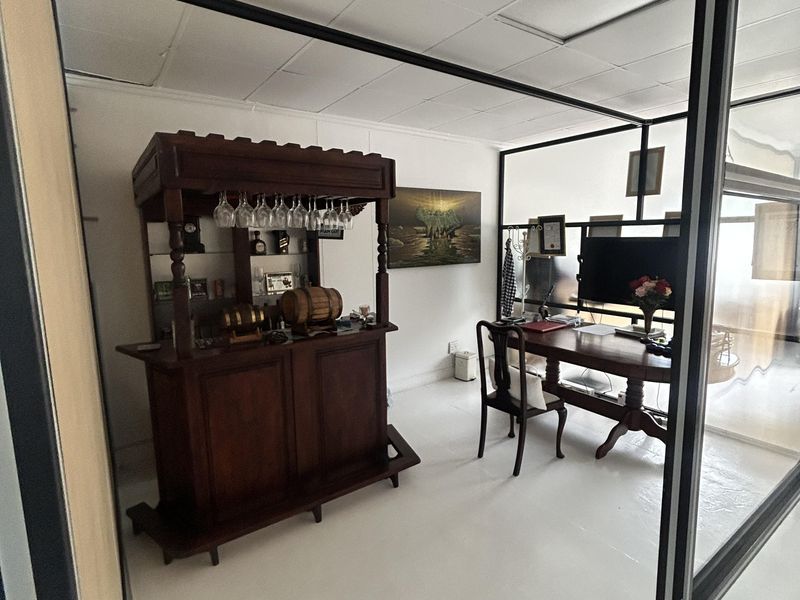 A functional office space featuring a suspended ceiling and modern glass partition walls, providing a professional environment suitable for various business needs.
