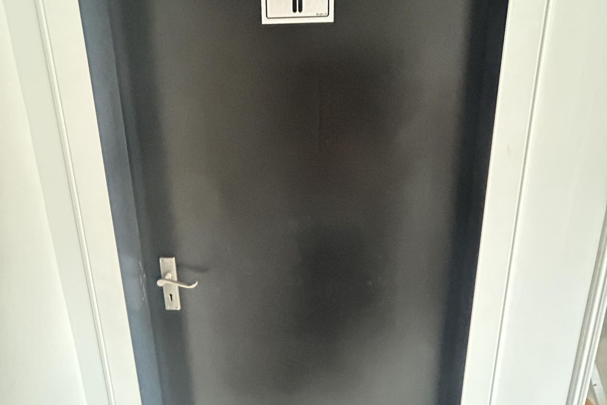 A view of a closed door leading to a female restroom facility within the office space.