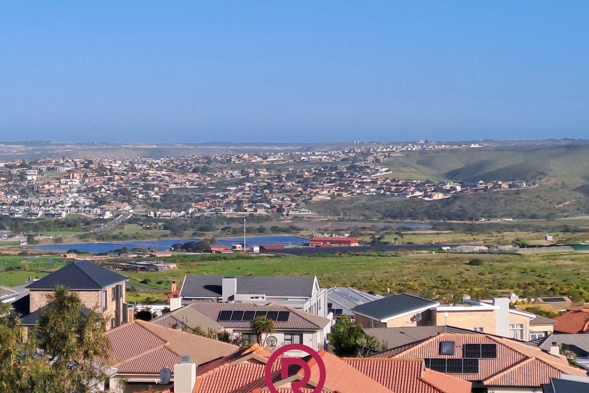 Elevated panoramic view overlooking a residential neighborhood, surrounding landscape, and distant coastal terrain.