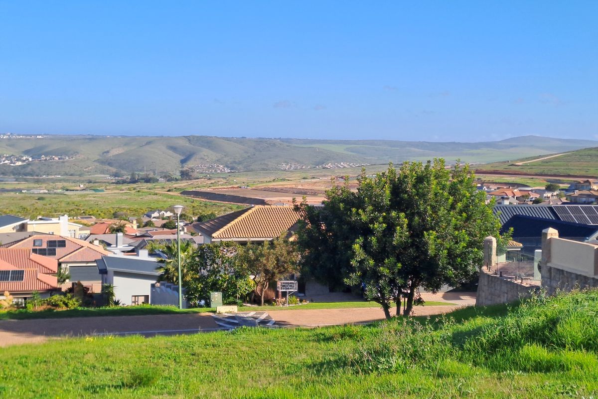 A scenic elevated view overlooking a residential neighborhood and surrounding rolling hills, showcasing the landscape and local development.