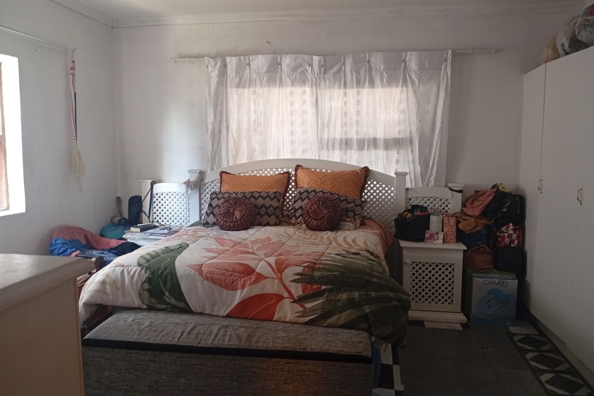 A bedroom featuring a built-in wardrobe and window with curtain rod. The space requires cosmetic updates to improve the overall finish and appeal.