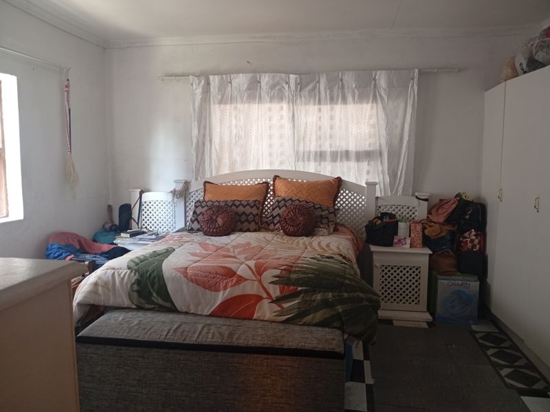 A bedroom featuring a built-in wardrobe and window with curtain rod. The space requires cosmetic updates to improve the overall finish and appeal.