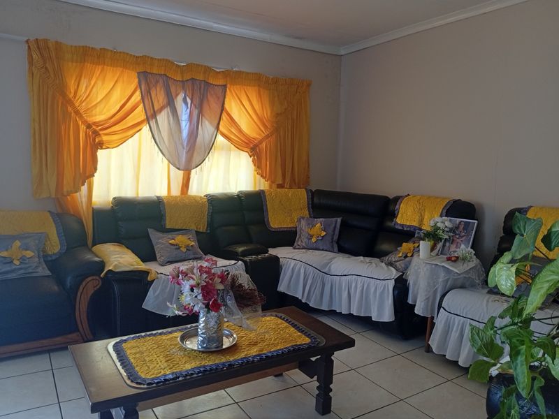 A living room area featuring tiled flooring and window treatments, providing a functional space for relaxation.