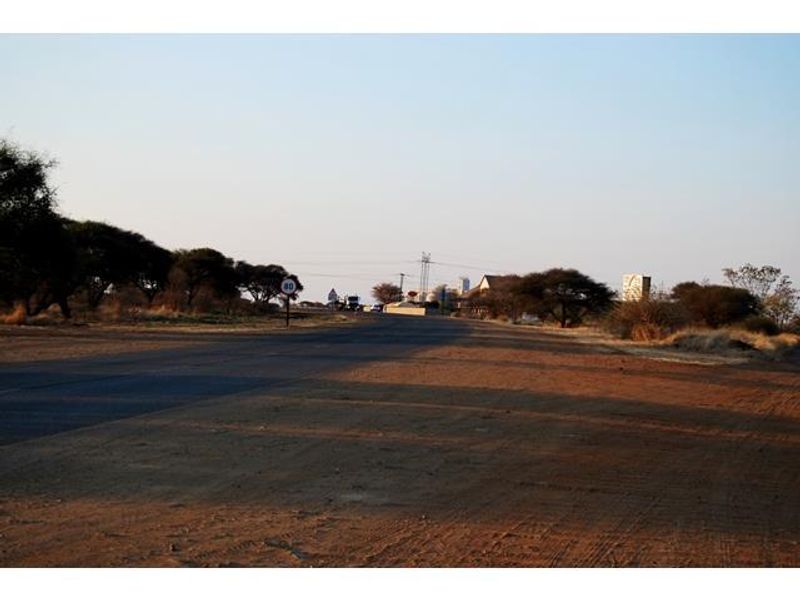 A view of the asphalt road and surrounding landscape, showing the approach to the commercial property location.