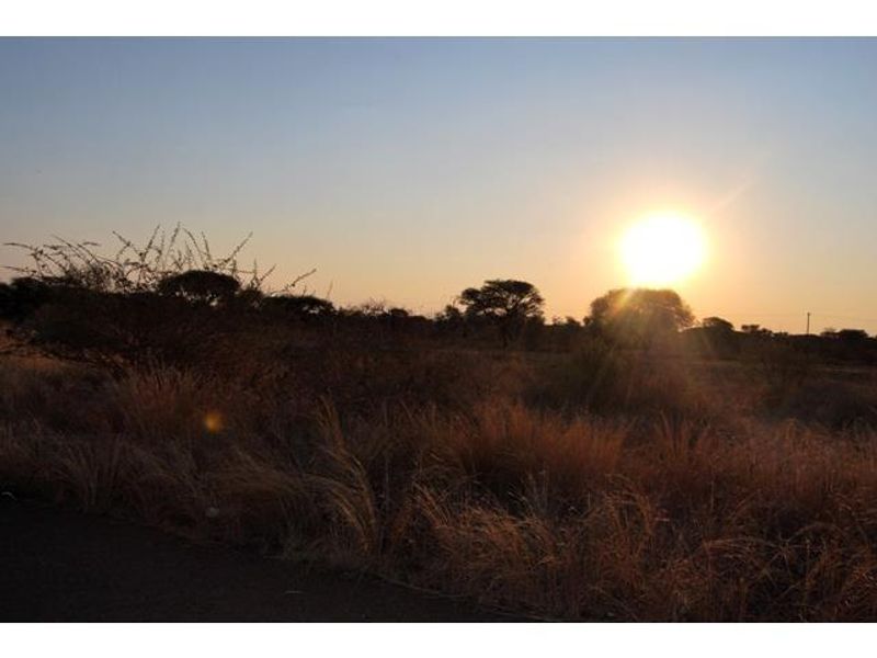 A scenic view of the vacant commercial land at sunset, featuring natural vegetation and open terrain.