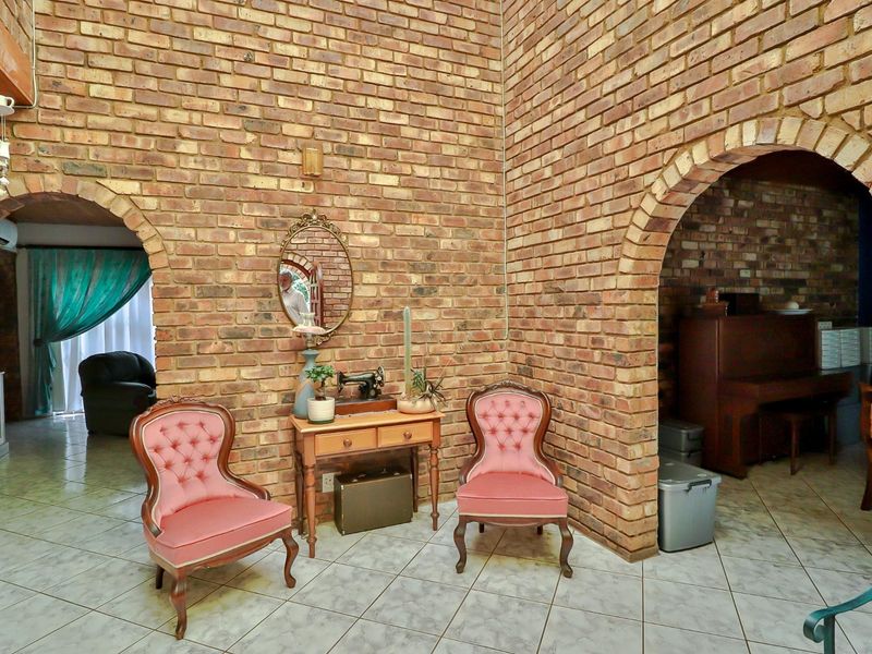 A living area featuring distinctive exposed brick walls, arched architectural openings, and tiled flooring, offering a rustic and character-filled space.