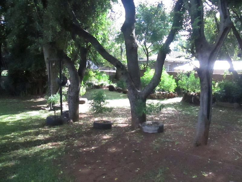 A spacious garden area featuring mature trees and established landscaping, providing a natural outdoor setting.