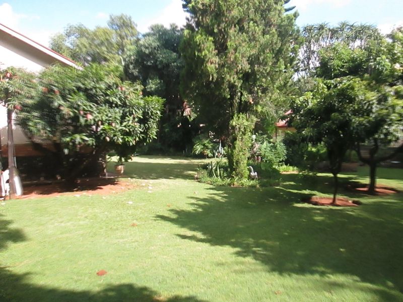 A lush, well-maintained garden area featuring mature trees, established landscaping, and a spacious lawn, providing a private outdoor setting.