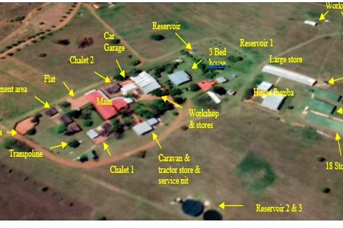 Aerial view of a farm property featuring multiple residential units, workshops, storage facilities, reservoirs, and a boma area.