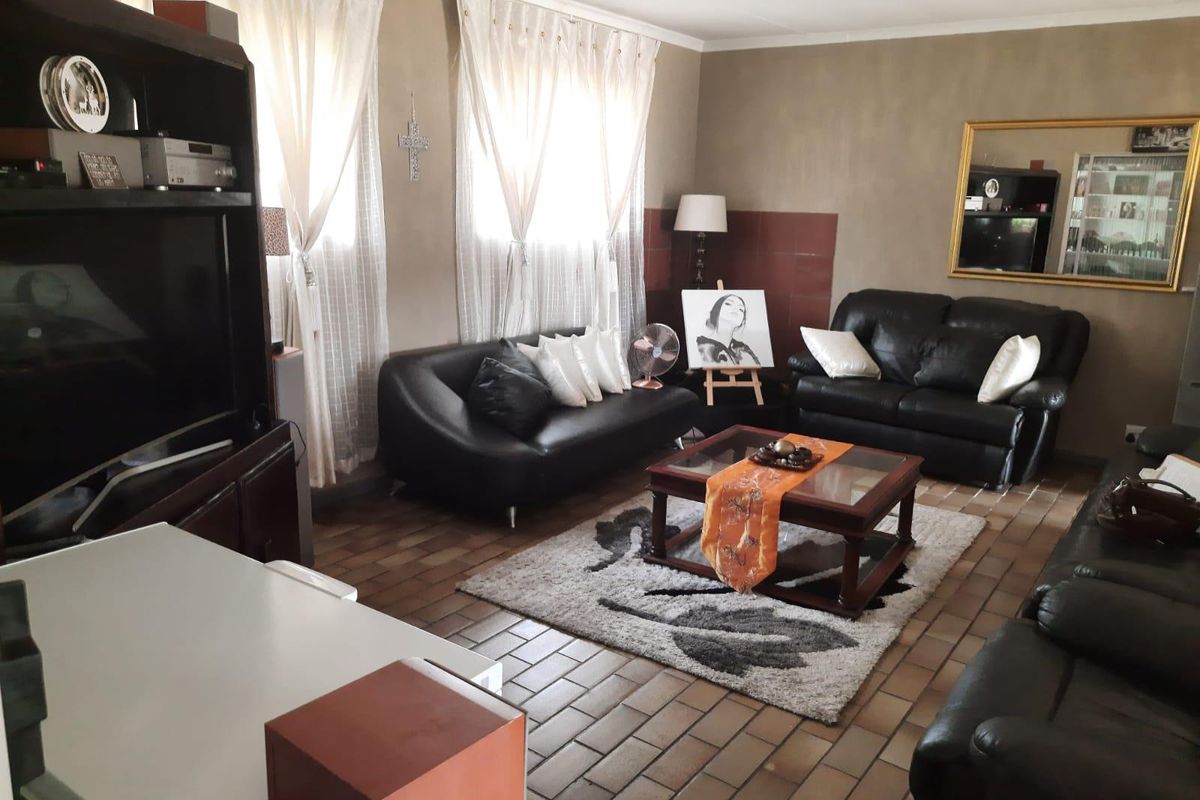 A spacious living room featuring durable tiled flooring and a ceiling fan, offering a comfortable and functional area for relaxation.