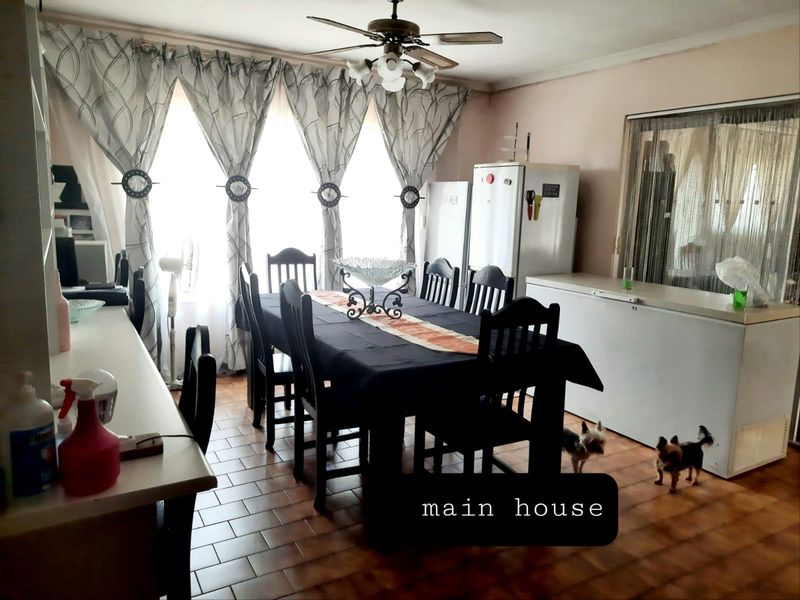 A dining room area featuring tiled flooring and a ceiling fan, providing a functional space for family meals.