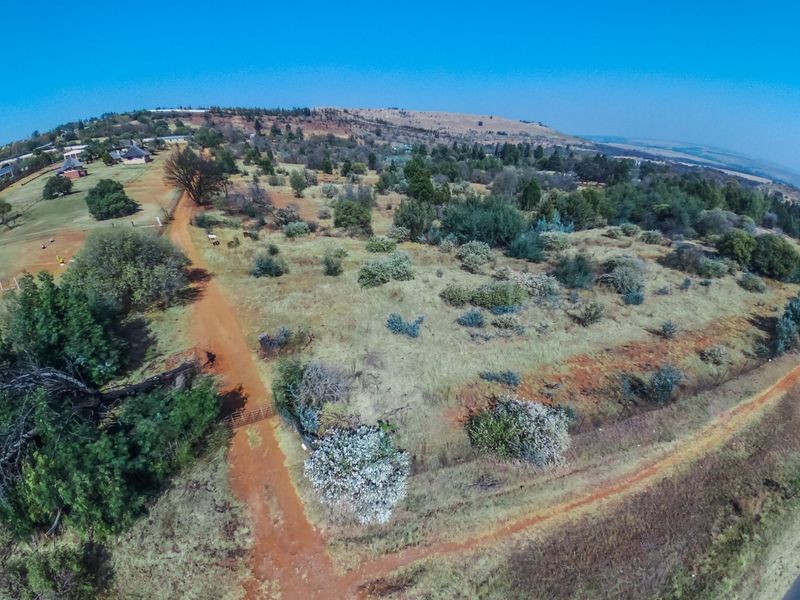 An aerial view of the expansive farm property featuring natural landscape, dirt access roads, and perimeter fencing.