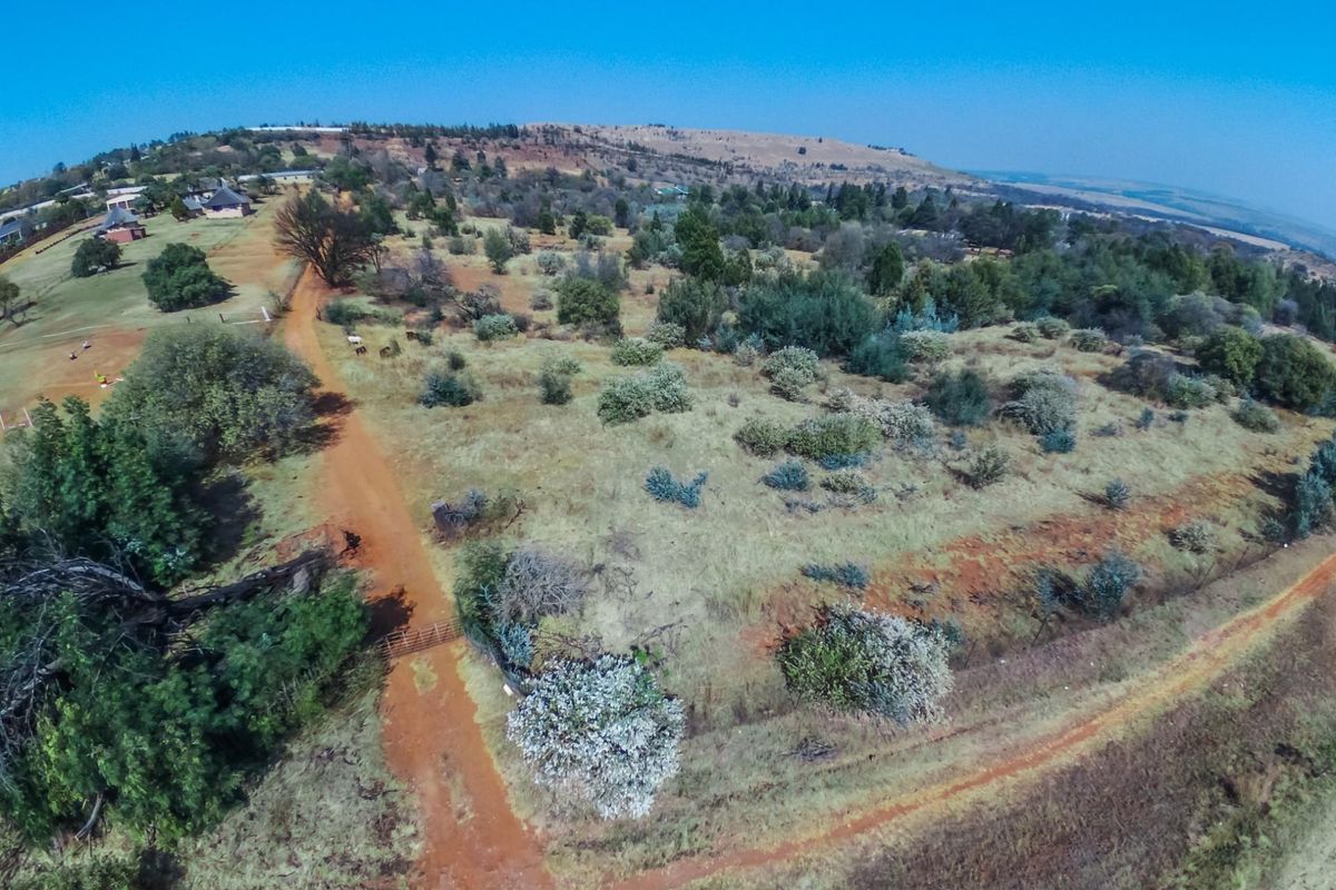 An aerial view of the expansive farm property featuring natural landscape, dirt access roads, and perimeter fencing.