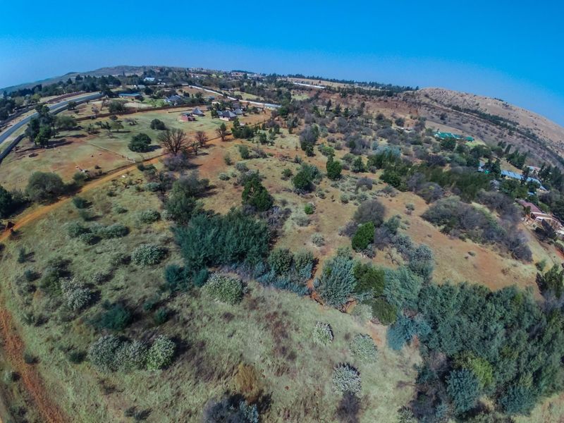An aerial view of the expansive farm property, showcasing the natural landscape, surrounding vegetation, and distant rural infrastructure.