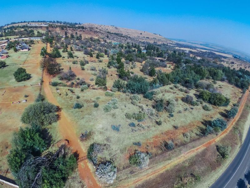 An aerial view of the expansive farm property, showcasing the landscape, dirt access roads, and surrounding vegetation.