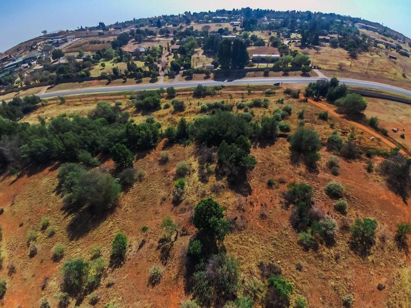 An aerial view of the farm property showing the surrounding landscape, vegetation, and proximity to the main access road.
