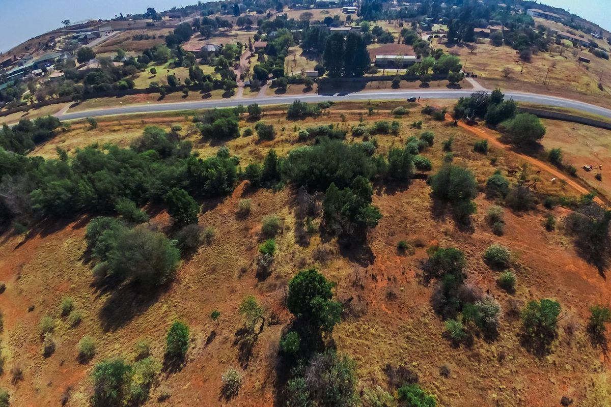 An aerial view of the farm property showing the surrounding landscape, vegetation, and proximity to the main access road.