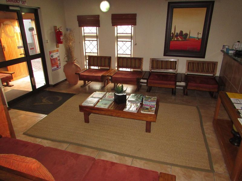 A functional office reception area featuring tiled flooring, a security entrance door, and a dedicated reception counter space.