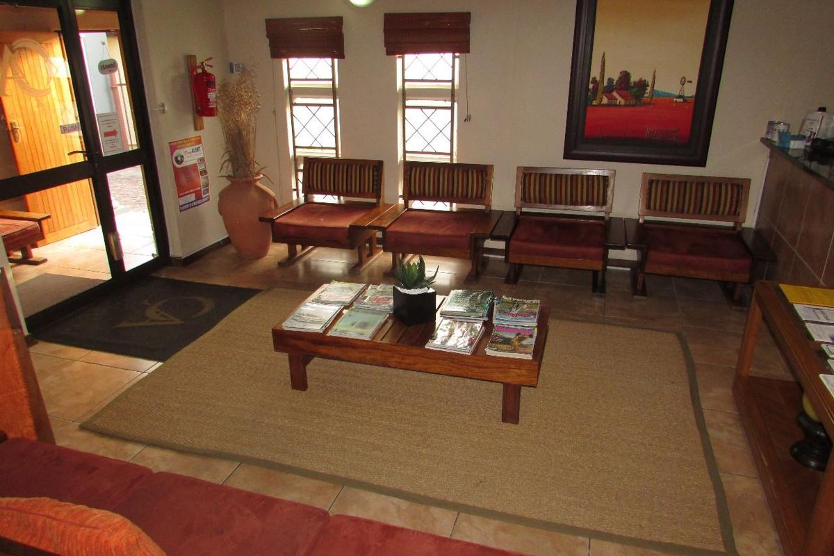 A functional office reception area featuring tiled flooring, a security entrance door, and a dedicated reception counter space.