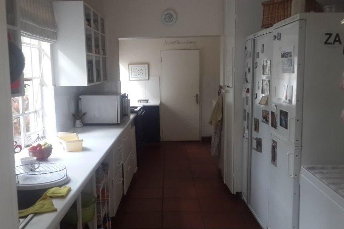 A functional kitchen featuring built-in cabinetry, tiled flooring, and natural light from a side window, providing a practical workspace for daily culinary activities.