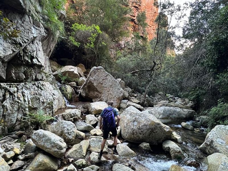 A natural landscape view featuring a rocky stream and cliff face, showcasing the property's surrounding natural environment.