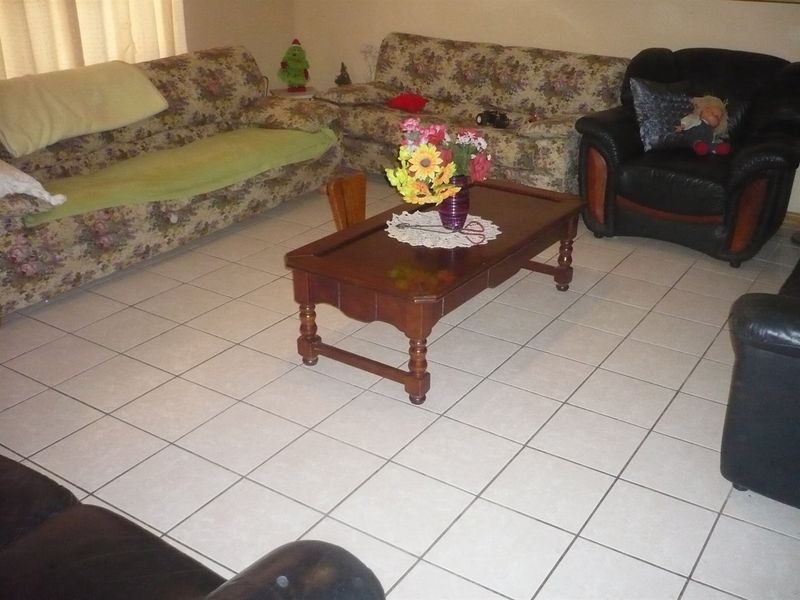 A living room area featuring neutral ceramic floor tiles, providing a functional and easily maintainable base for the space.
