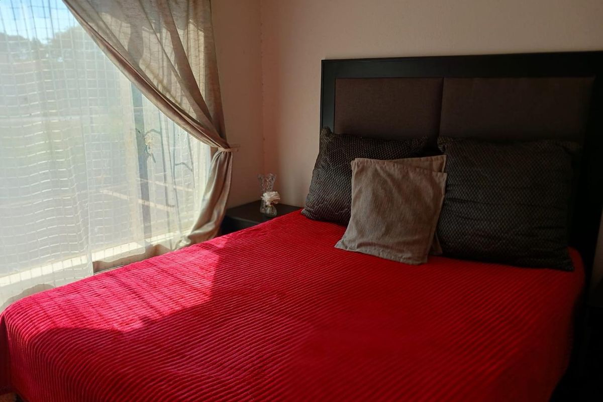 A cozy bedroom featuring a large window that allows for natural light, providing a comfortable and functional sleeping space.