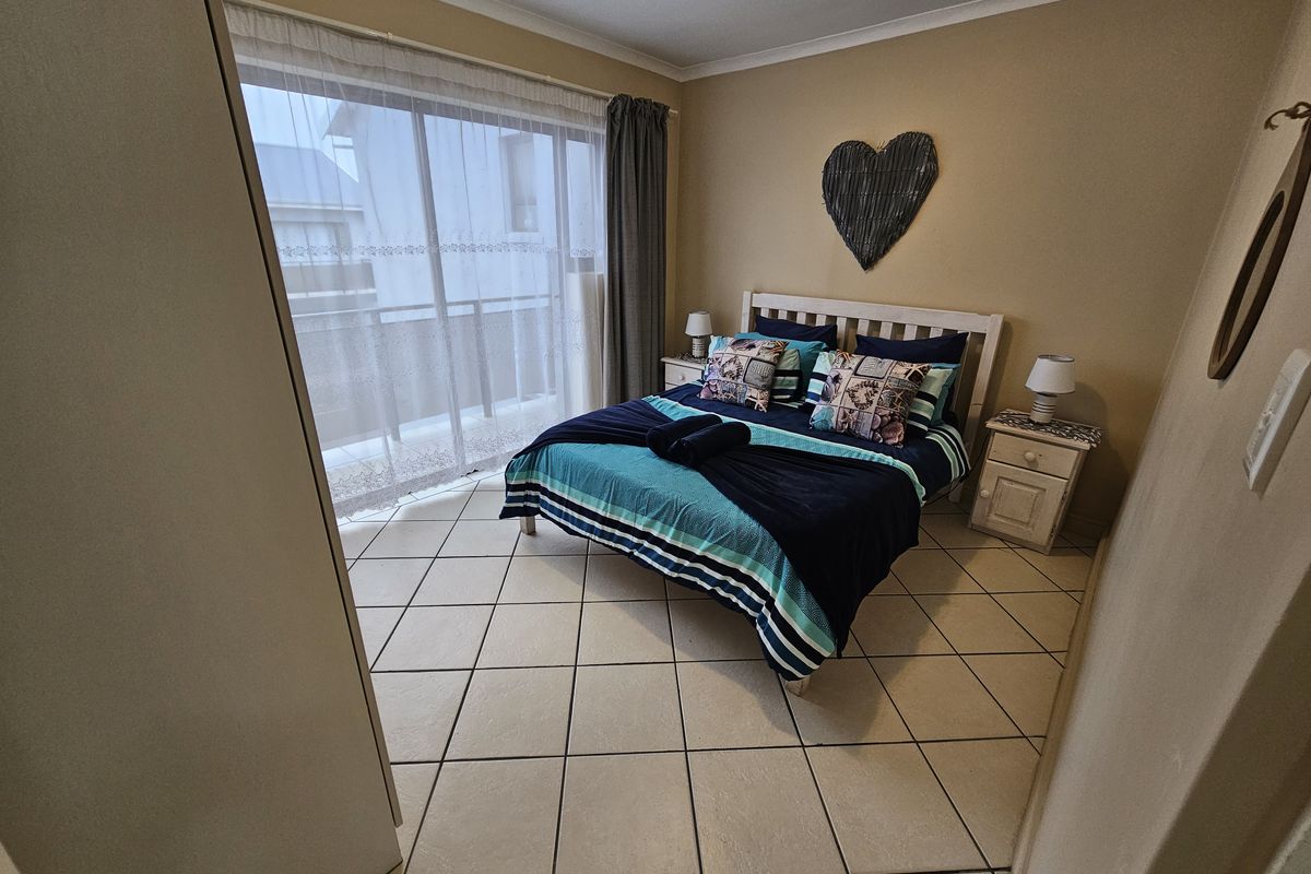 A bedroom featuring tiled flooring and a sliding glass door providing access to an outdoor balcony area.