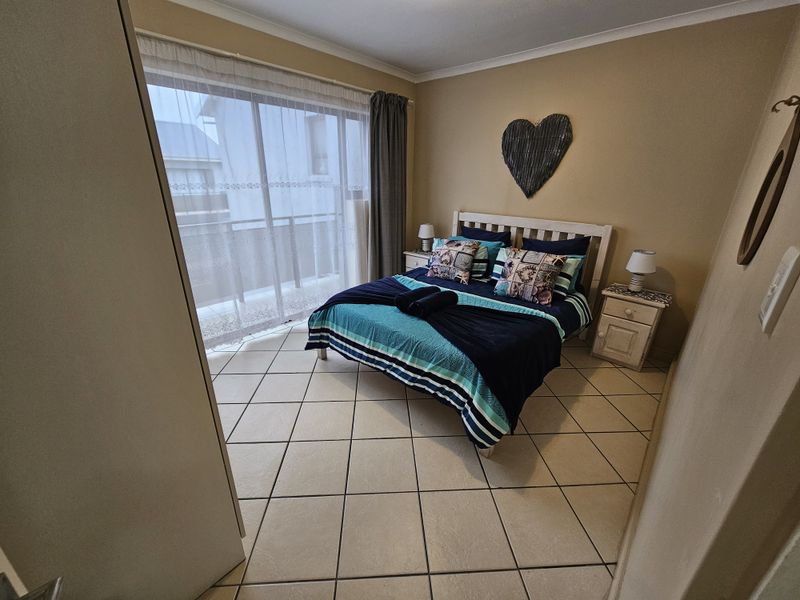 A bedroom featuring tiled flooring and a sliding glass door providing access to an outdoor balcony area.