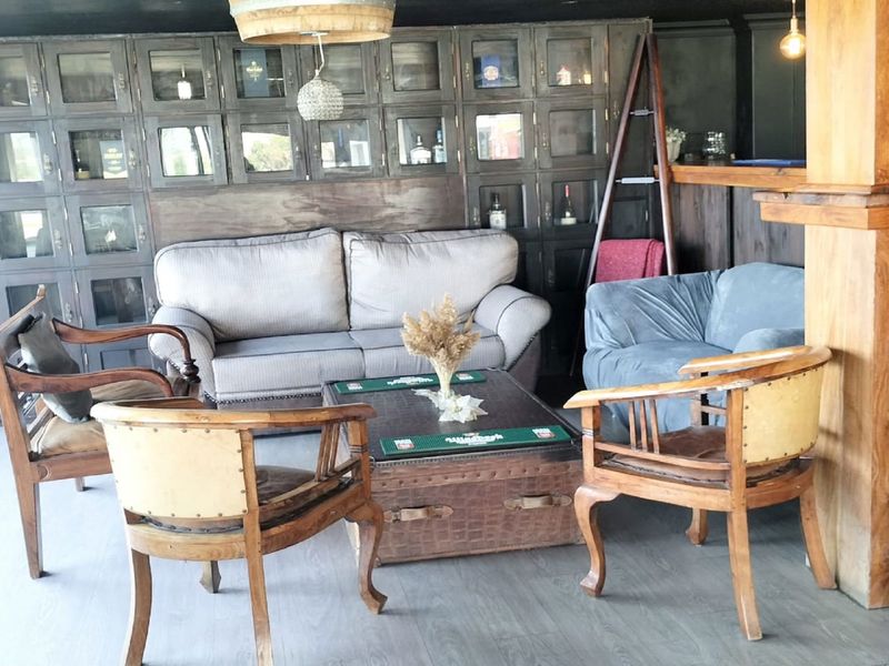 A rustic-style bar area featuring extensive built-in dark wood display cabinetry and a solid timber bar counter.