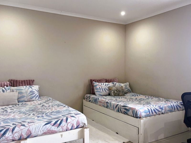 A bedroom featuring neutral wall tones, recessed ceiling lighting, and coving detail.