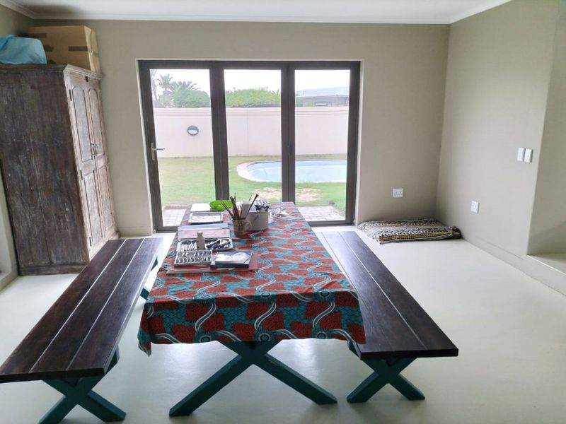 Dining area featuring polished concrete floors and large sliding glass doors providing direct access to the rear garden and pool area.