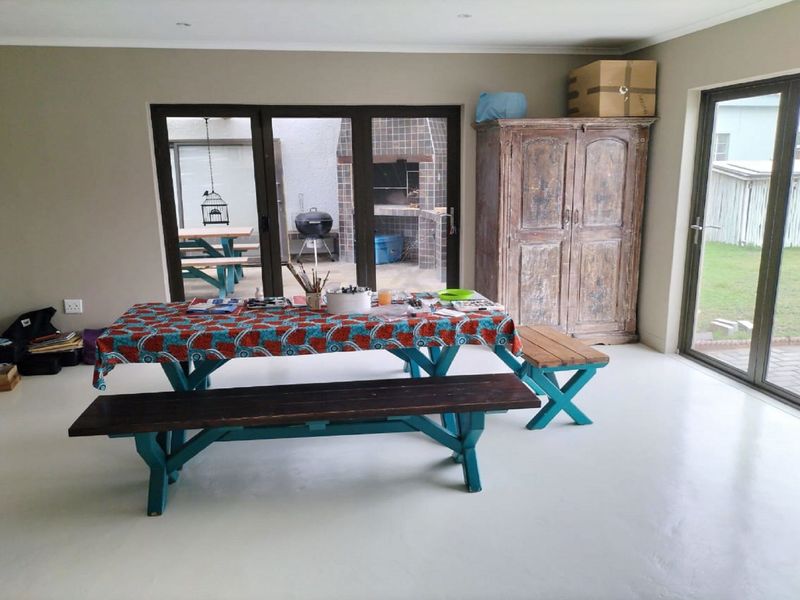Spacious living area featuring polished concrete floors, recessed lighting, and large aluminium sliding doors providing seamless access to the outdoor patio and garden.