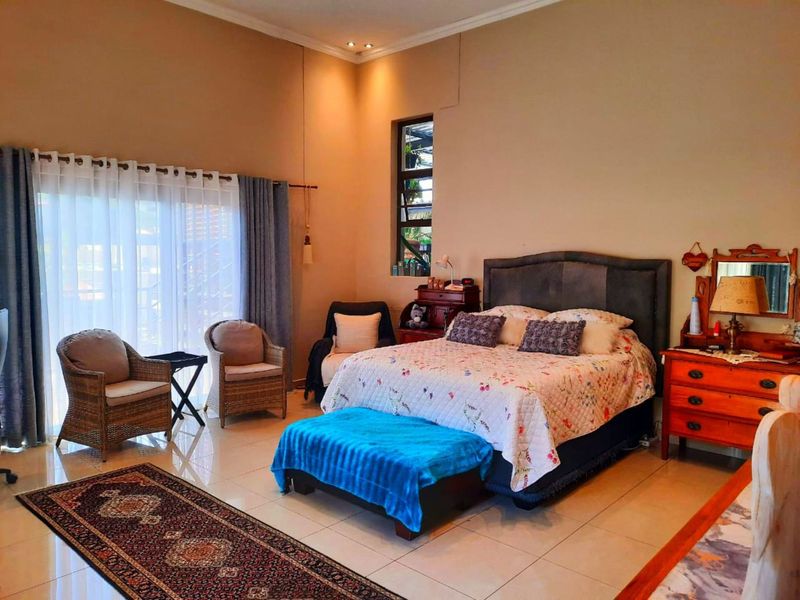 Spacious bedroom featuring tiled flooring, recessed lighting, and a large sliding glass door providing access to the outdoors.