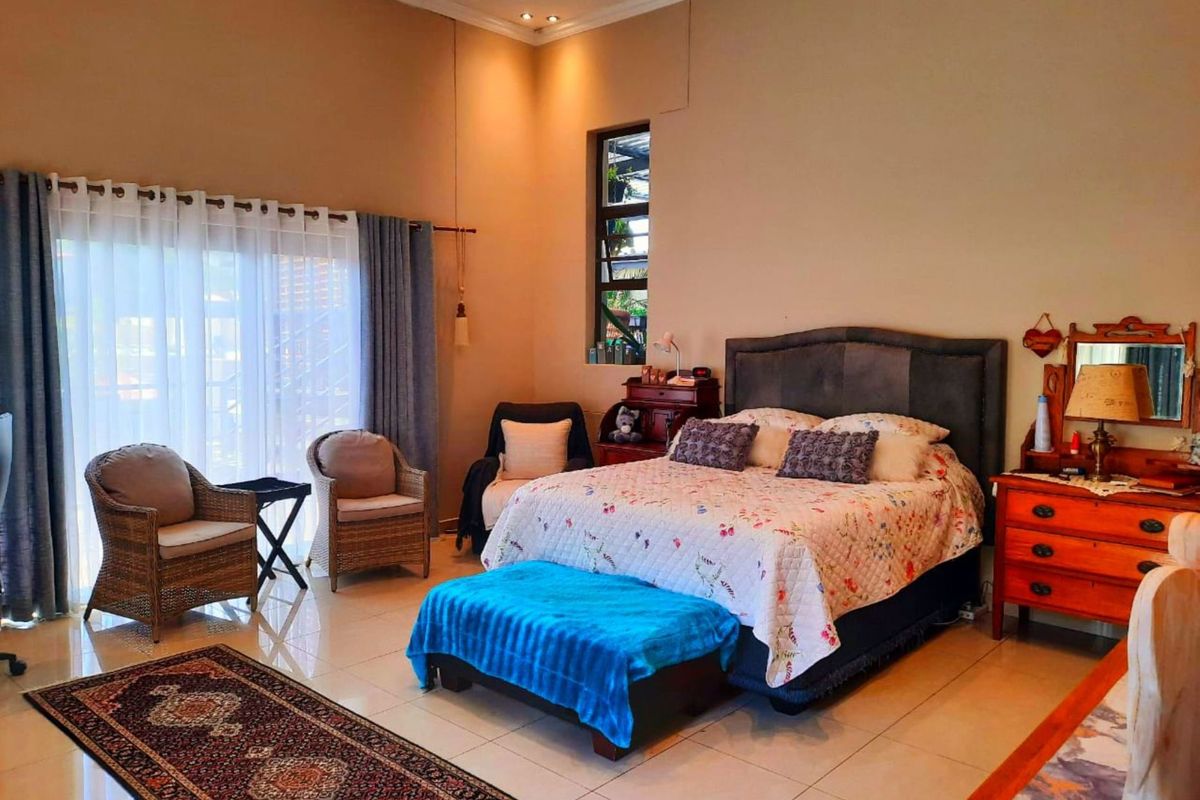 Spacious bedroom featuring tiled flooring, recessed lighting, and a large sliding glass door providing access to the outdoors.