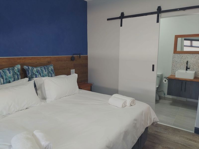 A well-maintained bedroom featuring a modern sliding barn door leading to an en-suite bathroom with a contemporary vanity and vessel sink.