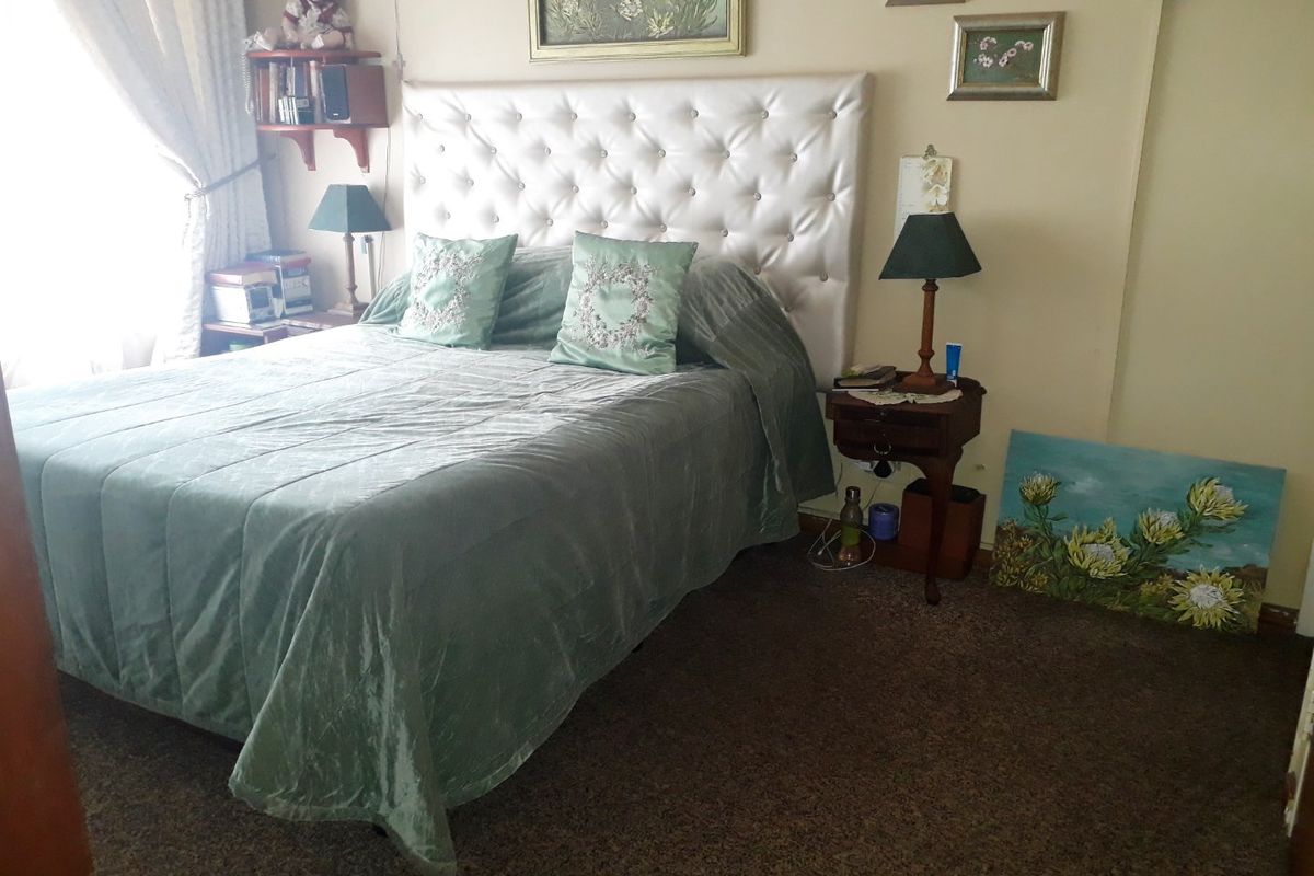 A bedroom featuring carpeted flooring and a tufted headboard, providing a comfortable and functional sleeping space.