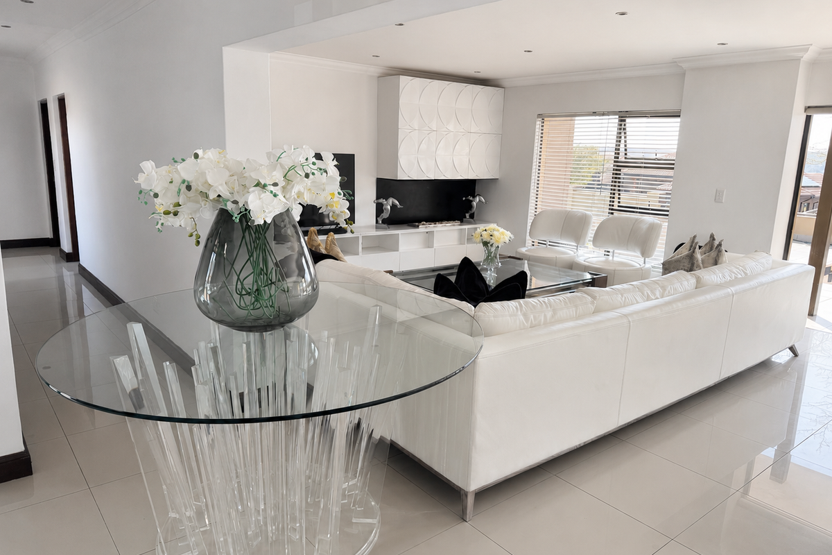 A bright and modern living room featuring polished porcelain floor tiles, recessed downlighting, and custom built-in media cabinetry.