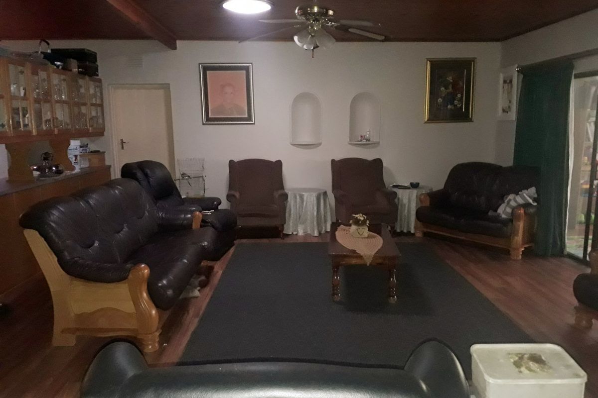 Spacious living room featuring a timber-paneled ceiling, built-in wall niches, and sliding door access to the exterior.