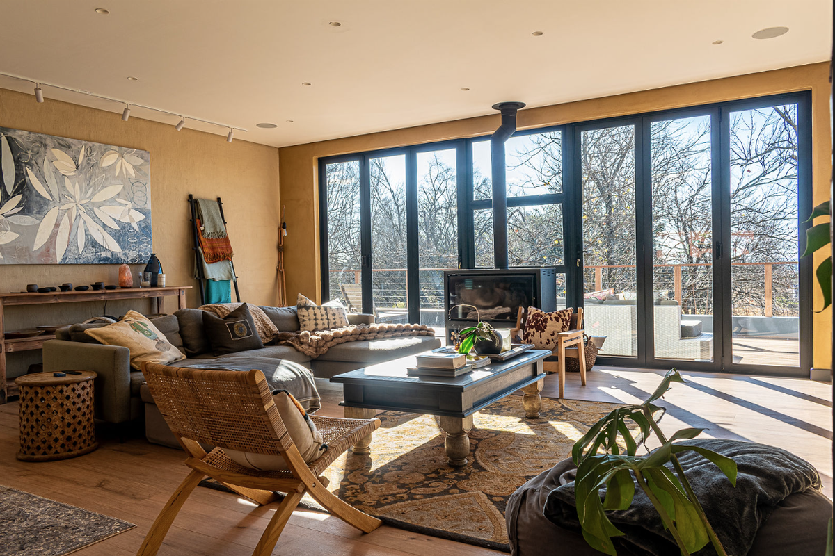 Spacious living room featuring a modern wood-burning fireplace, large bi-fold doors opening to an outdoor area, and warm recessed lighting.