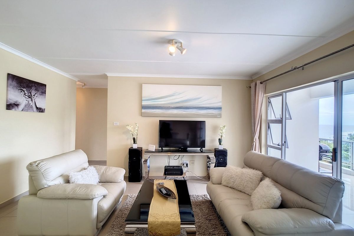 A bright and spacious living room featuring tiled flooring, neutral walls, and large sliding glass doors that provide access to an outdoor balcony area.