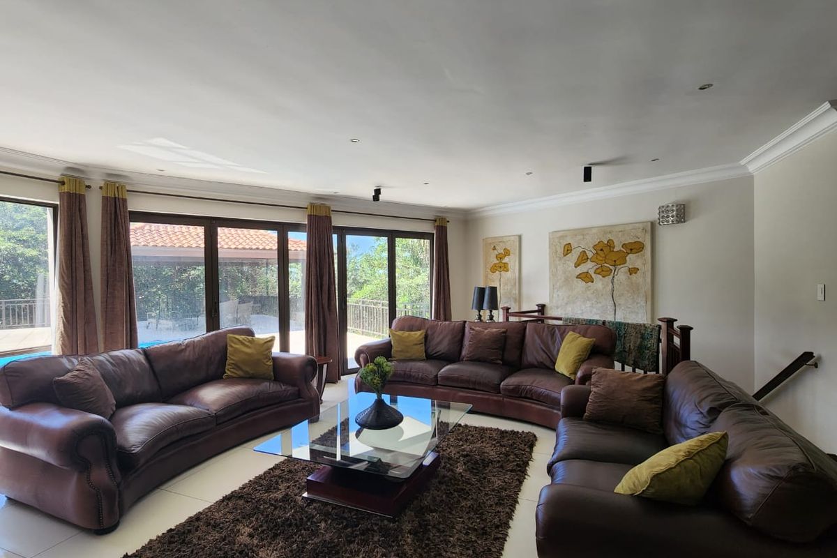 Spacious living room featuring large glass sliding doors that open onto an outdoor patio area, providing ample natural light and a seamless indoor-outdoor flow.