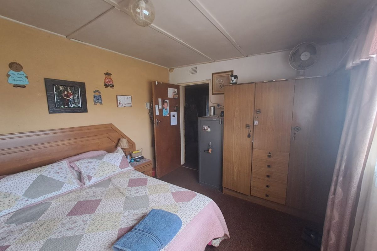 A bedroom featuring a built-in wooden wardrobe, carpeted flooring, and standard ceiling finishes.