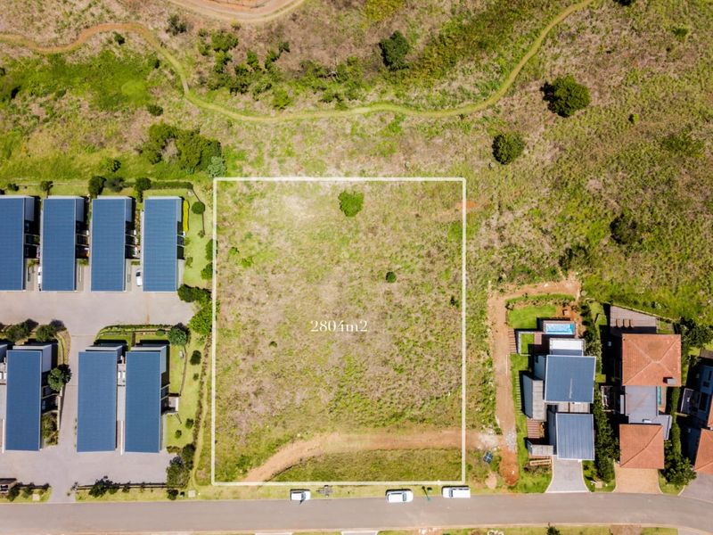 An aerial view of a 280m2 vacant residential plot situated within a developed estate, ready for new construction.