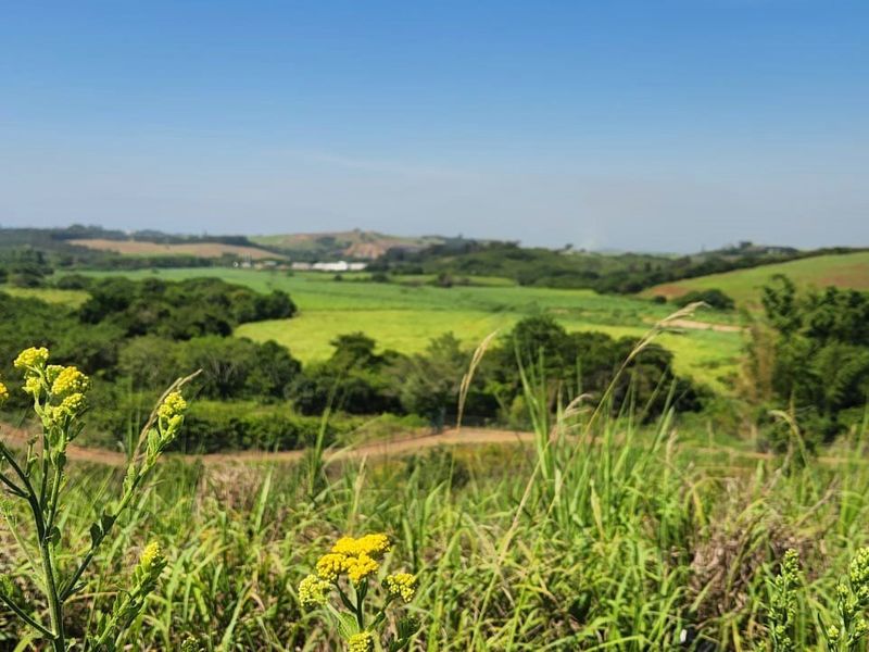 A scenic, elevated view overlooking expansive green fields and rolling hills, showcasing the natural landscape of the vacant residential land.