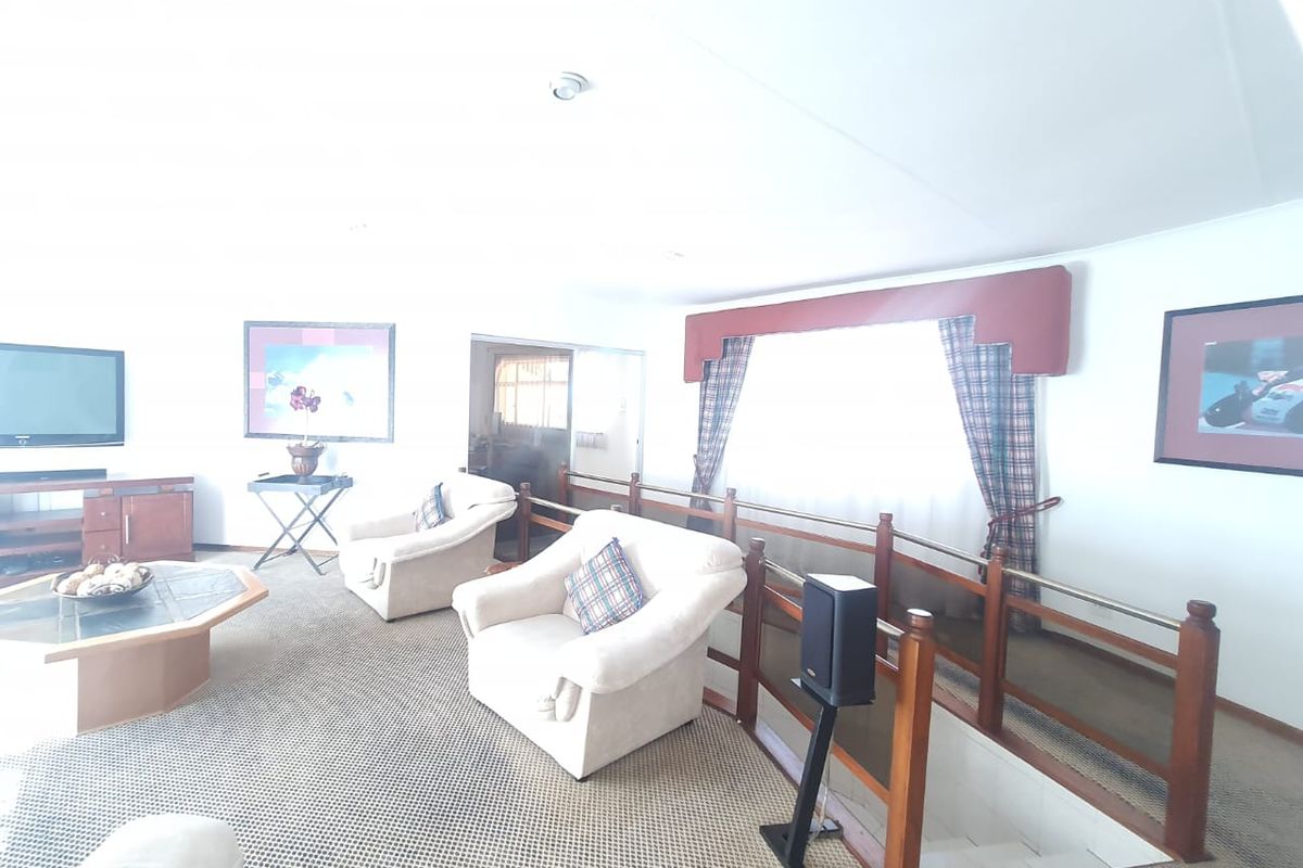 Spacious living area featuring a unique split-level design with timber balustrades and carpeted flooring.