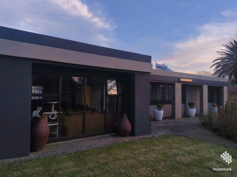 Rear exterior view of the house featuring a paved patio, sliding glass doors, and a solar water heating system on the roof.