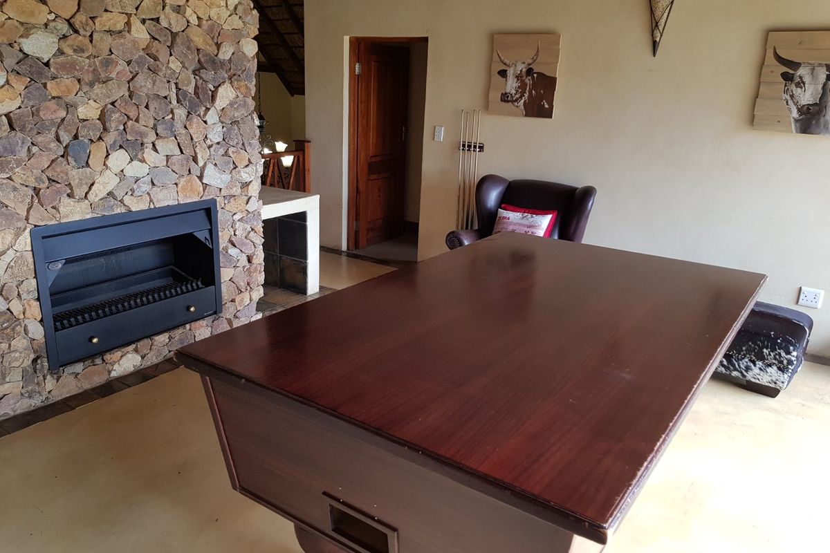 A living area featuring a prominent stone-clad fireplace and smooth flooring, providing a rustic and cozy atmosphere.