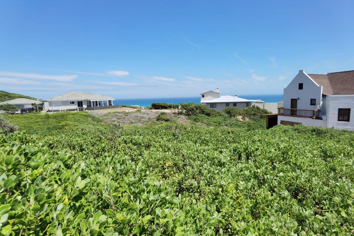 A scenic view overlooking a coastal landscape with surrounding residential properties and a clear ocean horizon.