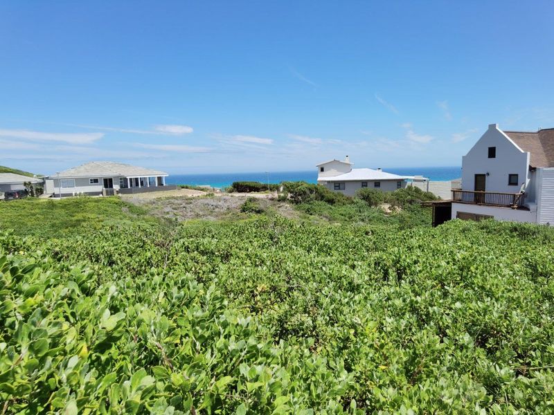 A scenic view overlooking a coastal landscape with surrounding residential properties and a clear ocean horizon.